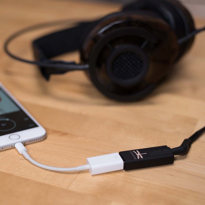 AudioQuest DragonFly Black — connected to iPhone via Lightning adapter with headphones