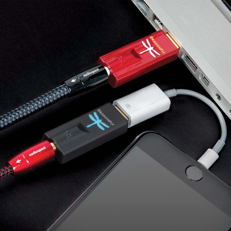 AudioQuest DragonFly Black — plugged into iPhone via Lightning adapter alongside DragonFly Red in laptop USB port