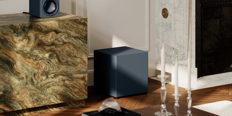 DALI BASIK SUB in Chilly Blue on a wooden floor beside a marble cabinet