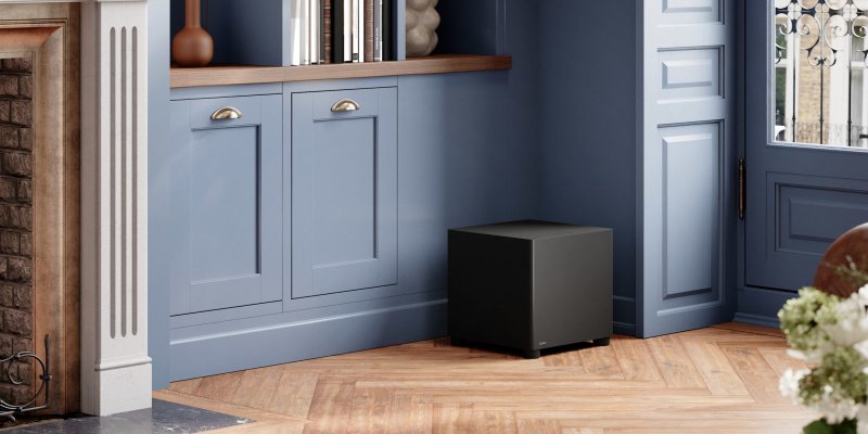 DALI BASIK SUB in Solid Black positioned beside fitted cabinetry