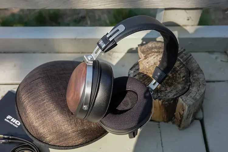 FiiO FT1 Black Walnut headphones resting on carry case outdoors
