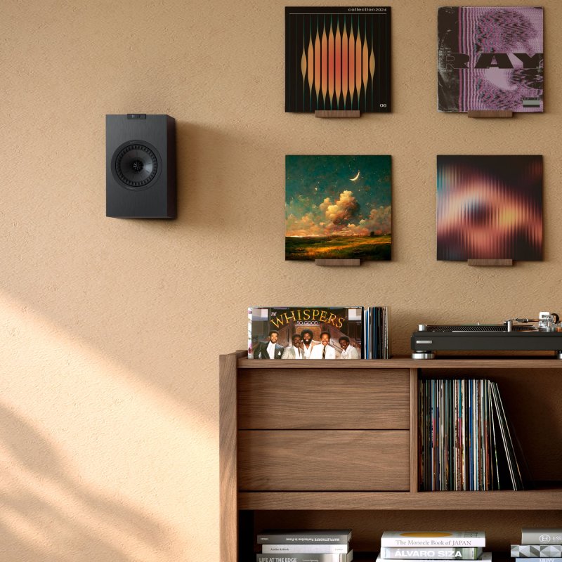 KEF Q1 Meta Bookshelf Speaker wall mounted in a living room, Satin Black finish shown