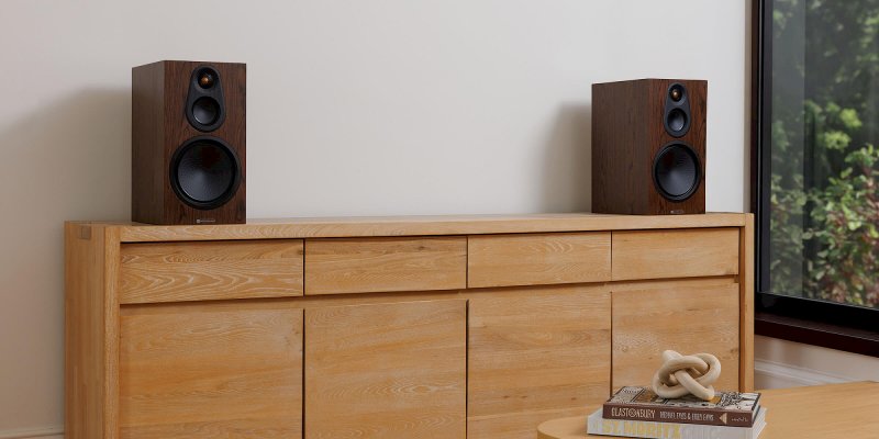 Monitor Audio Silver 100 8G European Walnut on a sideboard in a living room setting