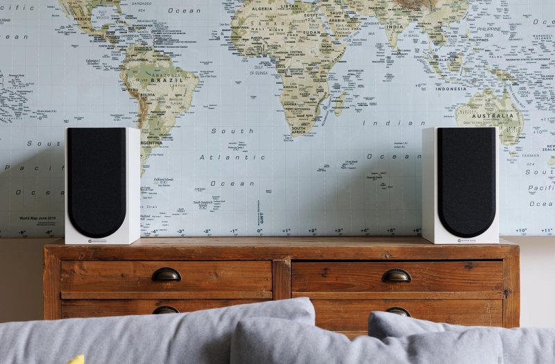 Monitor Audio Silver 100 8G Standmount Speakers Satin White (Pair) on a side table with grilles attached