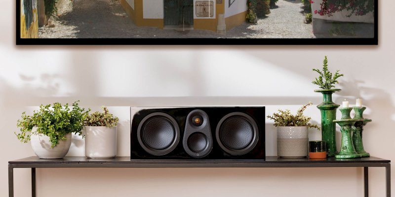Monitor Audio Silver Centre 8G in High Gloss Black on a console in a living room
