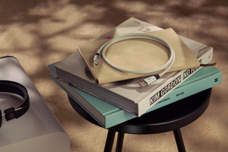 QED Performance USB cable coiled on a stack of books in a living room setting