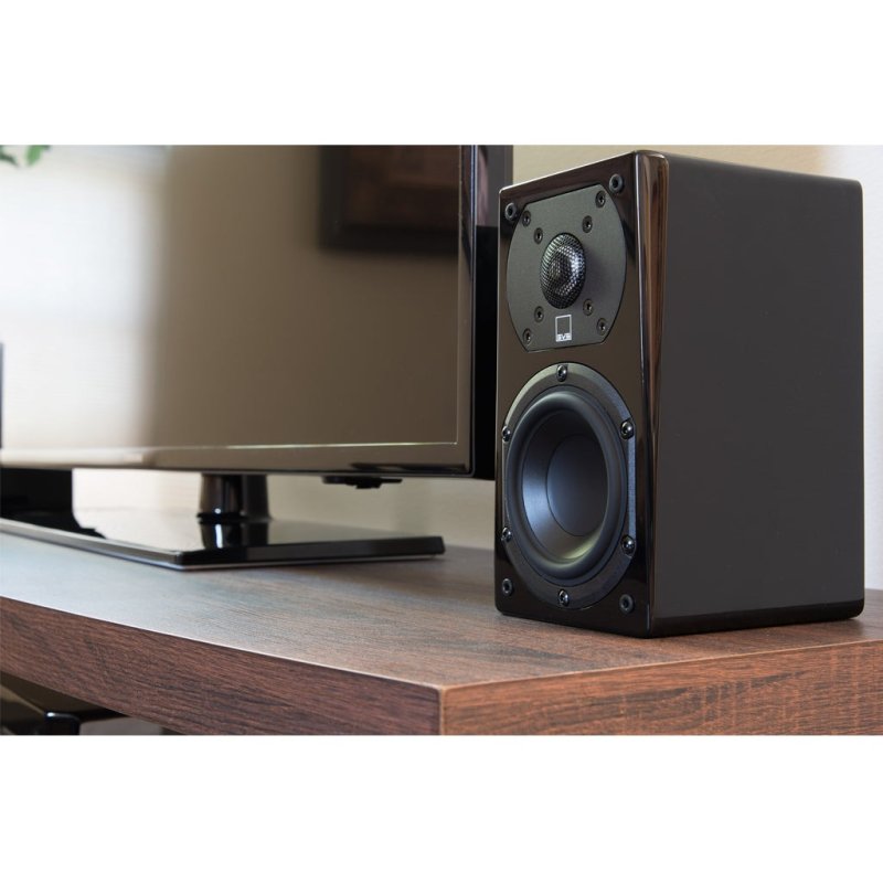 SVS Prime Satellite speaker beside a TV (Piano Gloss Black shown)