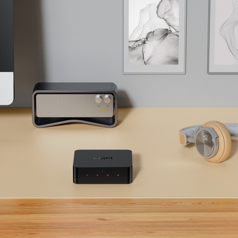 WiiM Pro Audio Streamer on desk with speaker and headphones